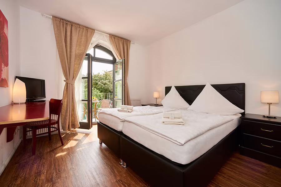 Family-Zimmer im Hotel Matzbach mit Doppelbett und Balkontür zum begrünten Innenhof
